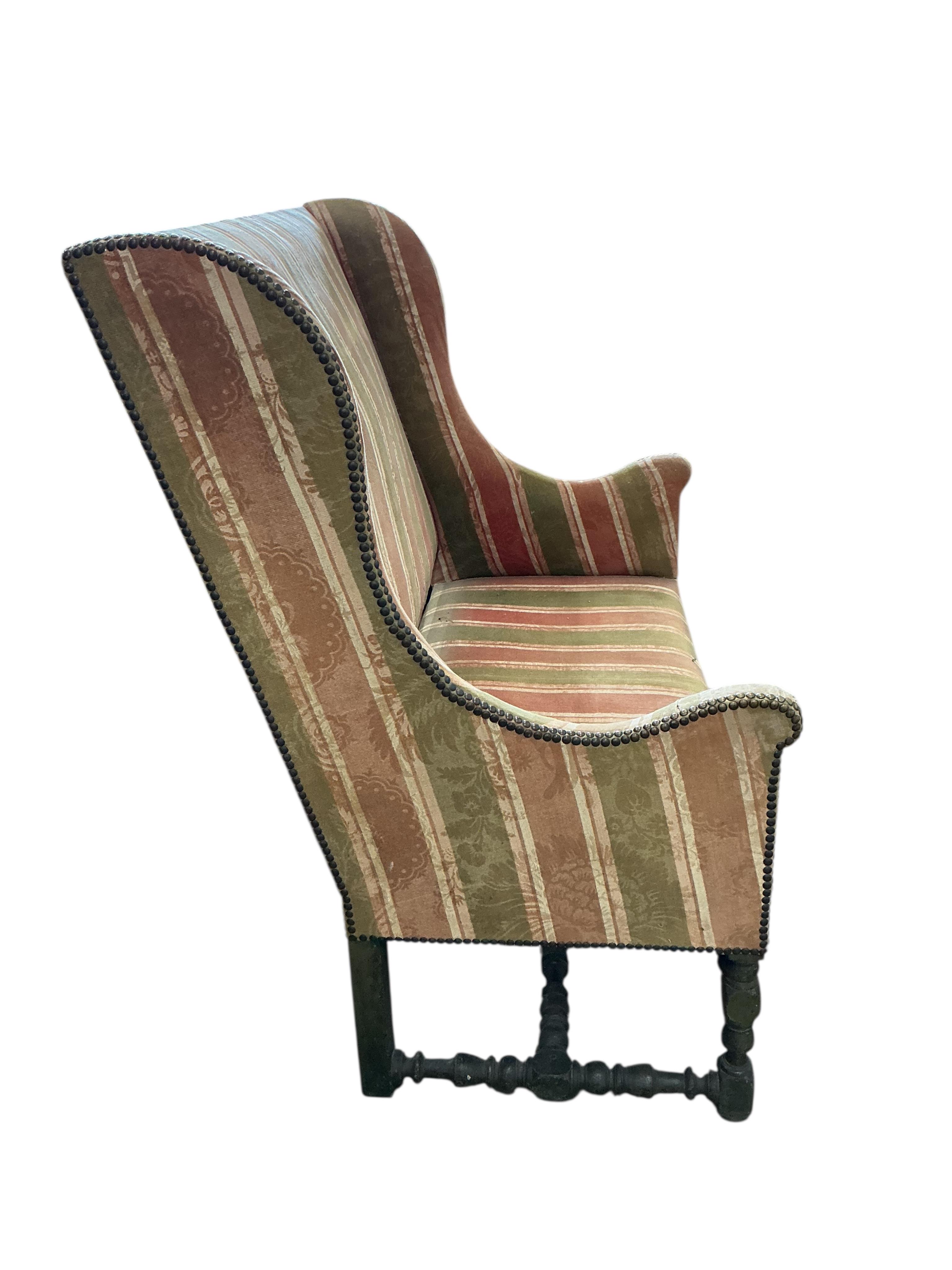 A mid 17th century upholstered high back settee on painted turned underframe. (Provenance, from the Great Hall, Luddesdown Court)